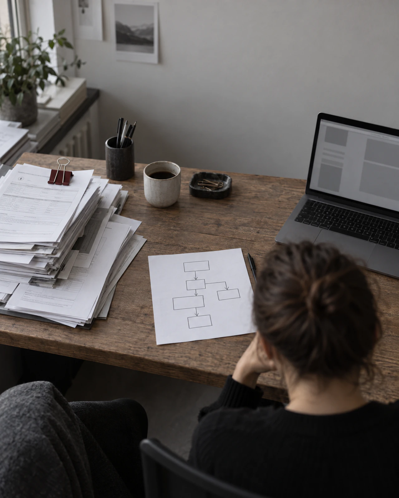 Papierstapel und ein skizzierter Ablauf neben dem Laptop: so beginnt eine Automatisierung