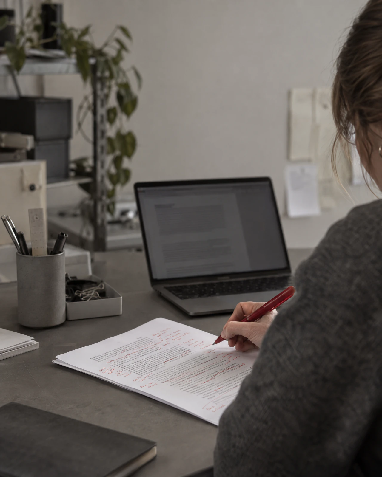 KI-Textentwurf ausgedruckt und von Hand mit rotem Stift korrigiert