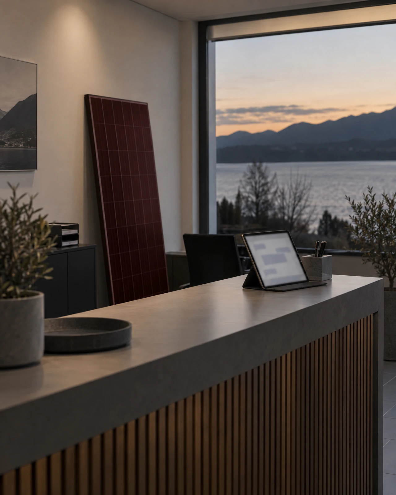 Tablet mit Chatfenster und ein Solarmodul in einem Büro mit Blick auf einen See in der Abenddämmerung